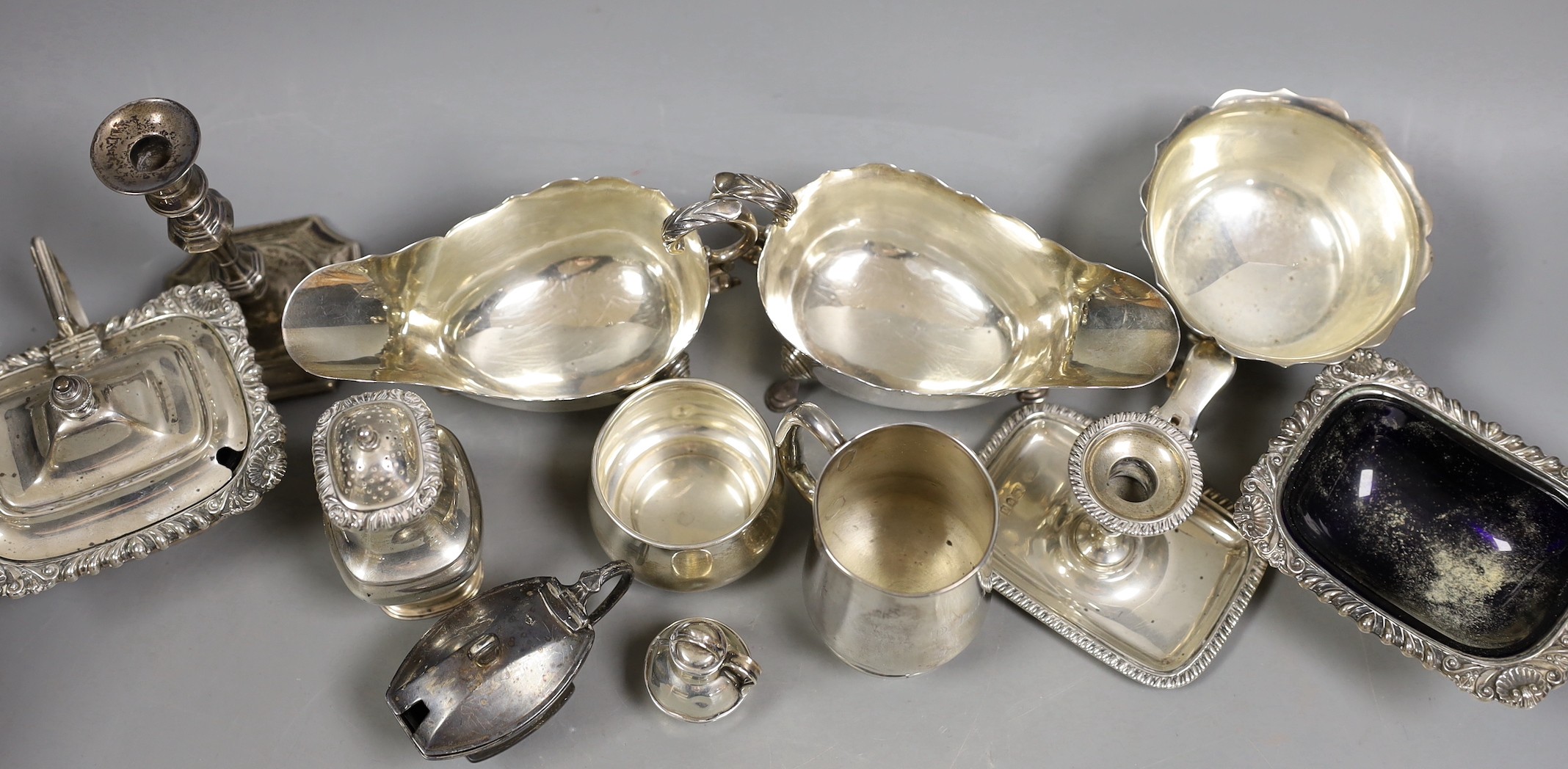 A pair of late Victorian silver sauceboats, Frederick Augustus Burridge, London, 1899, a George V silver mounted taperstick, a modern silver three piece condiment set, a silver chamberstick, silver mug, two silver small